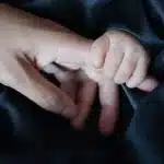 Silhouette orang dewasa dan tas punggung anak di bangku taman, suasana tenang