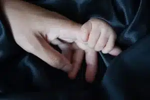 Silhouette orang dewasa dan tas punggung anak di bangku taman, suasana tenang