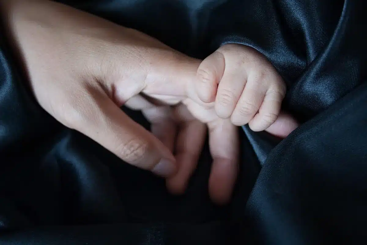 Silhouette orang dewasa dan tas punggung anak di bangku taman, suasana tenang